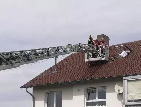 Feuerwehr-Drehleiter an einem Dachfenster