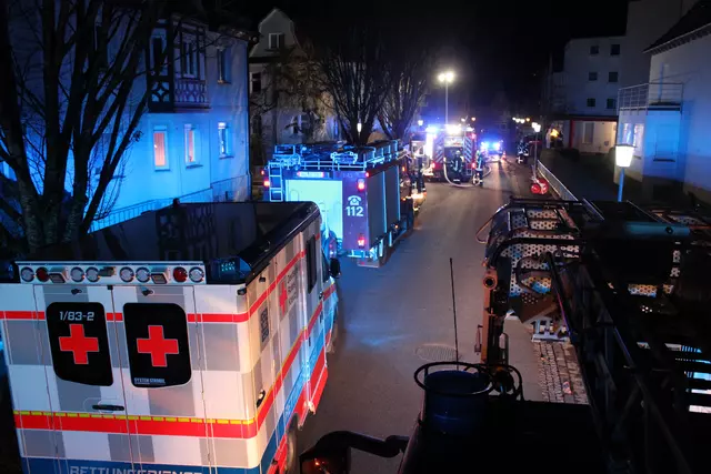 Rettungsdienst und Feuerwehr warten nachts in einer Straße